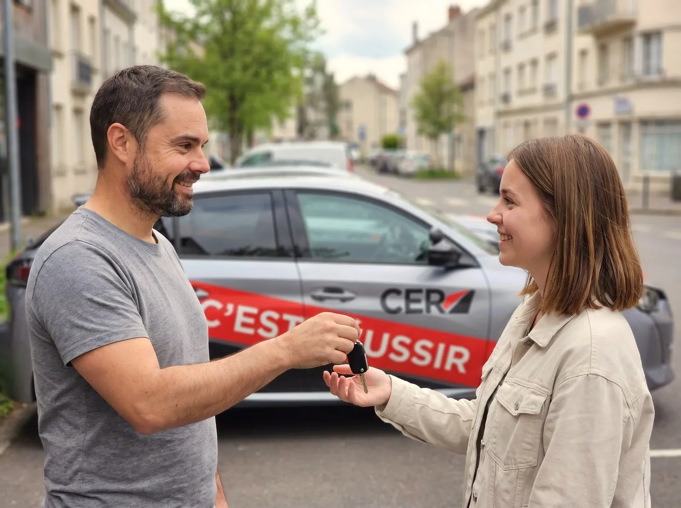 Aymeric, enseignant, remet les clés de la voiture-école à une élève